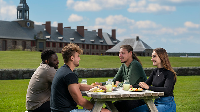 Visitors enjoying an outdoor meal at the Fortress of Louisbourg near Hôtel de la Marine Visitors enjoying an outdoor meal at the Fortress of Louisbourg near Hôtel de la Marine